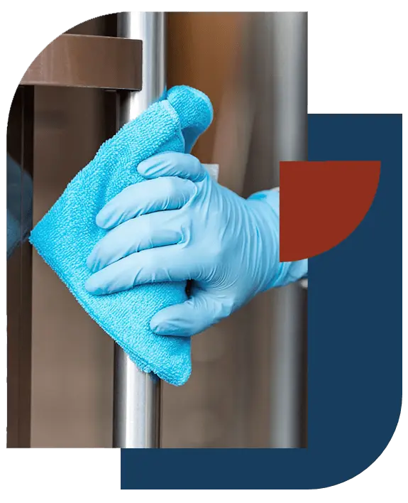 Gloved hand wiping a stainless steel door handle during a commercial cleaning in New Orleans